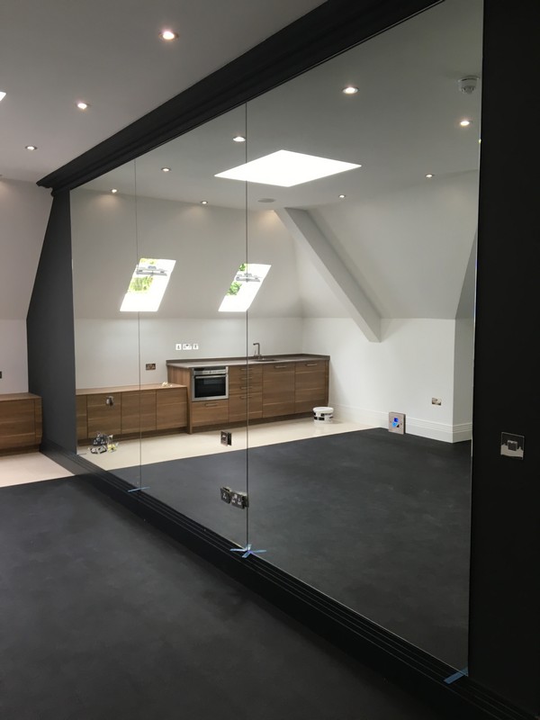 Frameless glass partition in loft conversion by Penge glaziers