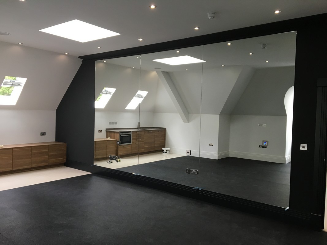 Frameless glass wall dividing loft conversion in Penge